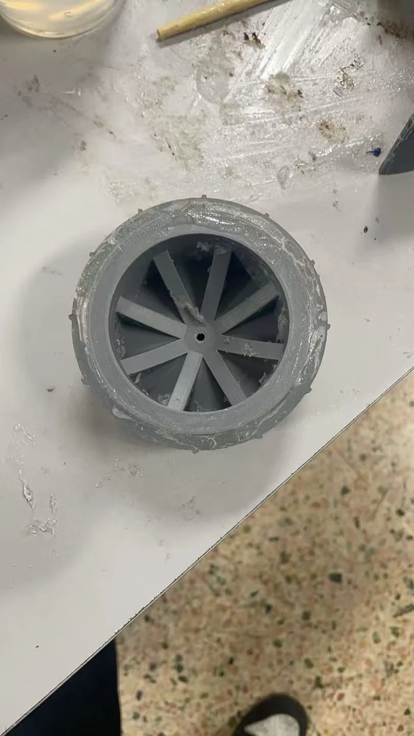 第一版轮胎实物:灰色辐条轮毂及胎面外圈 / V1 tire prototype with radial spokes and outer tread